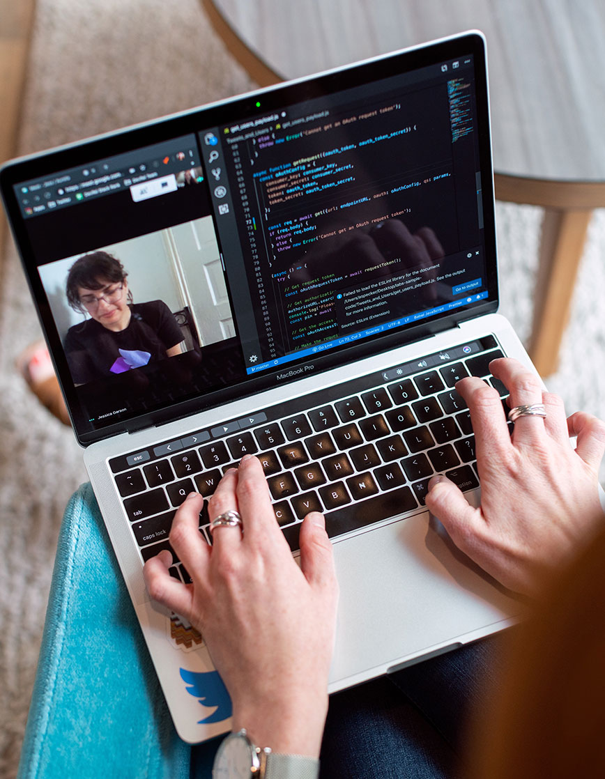Femme entrain de faire du développement web sur un ordinateur, une page avec des lignes de code est ouverte.